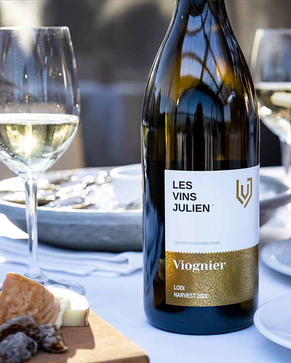 Bottle of Les Vins Julien Viognier wine sitting on table with cheese plate and oysters